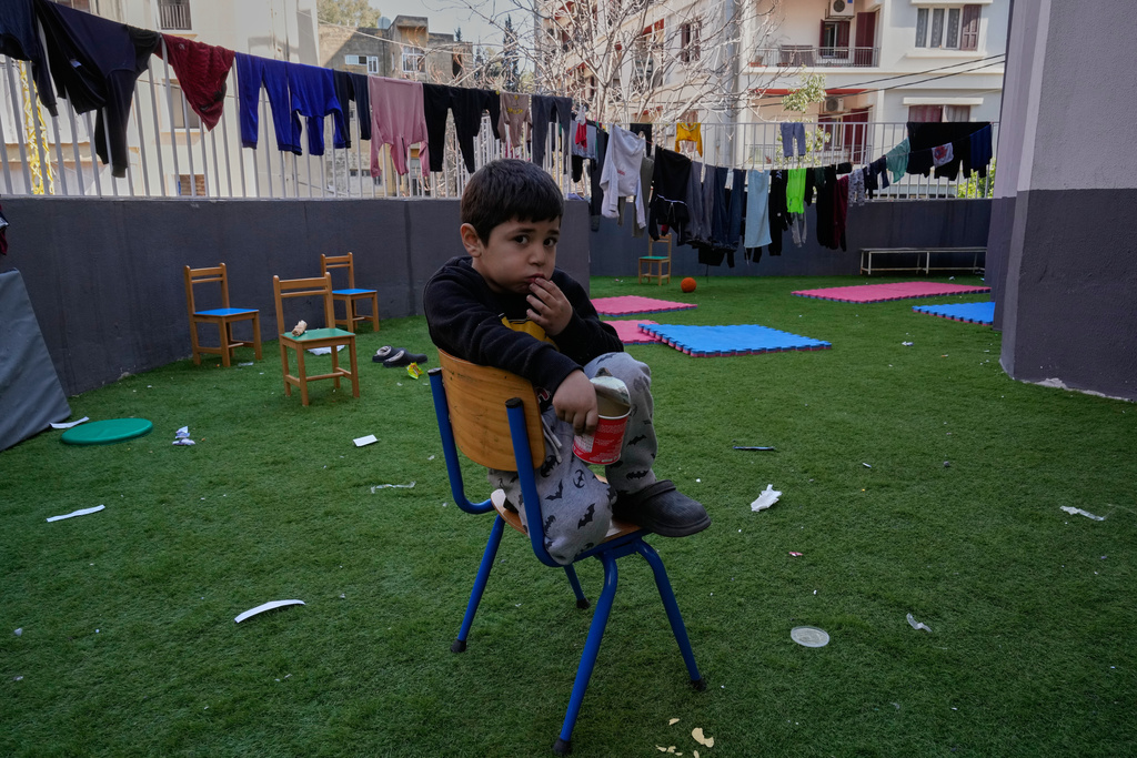 A displaced boy who fled Israeli strikes in southern Lebanon with his family sits on the backyard school that turned into a shelter in Beirut, Lebanon, Tuesday, March 10, 2026. (AP Photo/Hussein Malla)