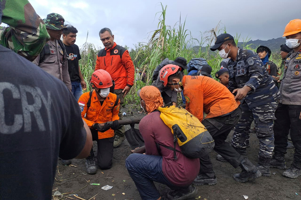 In this photo released by the Indonesian National Search and Rescue Agency (BASARNAS) rescuers carry the body of a victim of the eruption of Mount Dukono, on Halmahera Island, Indonesia, Saturday, May 9, 2026. (BASARNAS via AP)