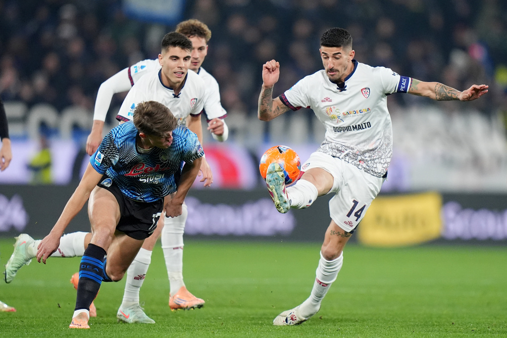 Atalanta's Charles De Ketelaere, front left, and Cagliari's Alessandro Deiola, right, challenge for the ball during the Serie A soccer match between Atalanta Bergamo and Cagliari Calcio in Bergamo, Italy, Saturday Dec. 13, 2025. (Spada/LaPresse via AP)