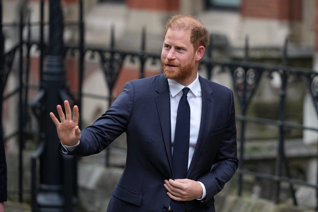 Britain's Prince Harry waves as he arrives at London's High Court to lead a group, including Elton John and Elizabeth Hurley, accusing the Daily Mail's publisher of privacy invasion through unlawful tactics in a trial that is part of a wider phone hacking scandal in London, Monday, Jan. 19, 2026. (AP Photo/Alastair Grant)