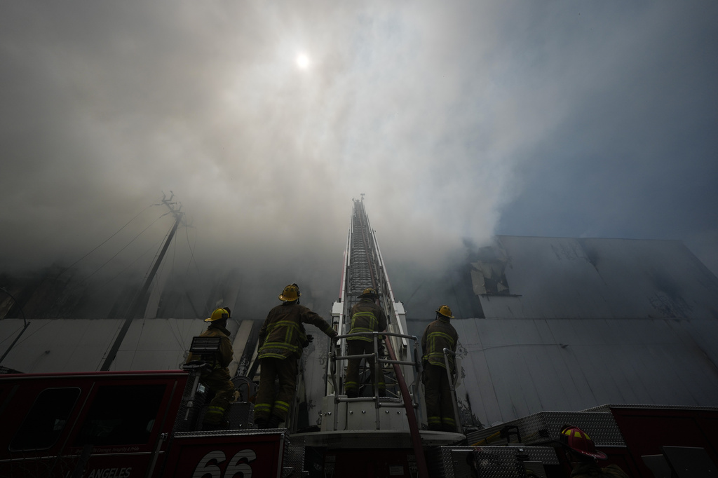 Firefighters fight a warehouse fire in the Boyle Heights neighborhood of Los Angeles, Sunday, June 21, 2026. (AP Photo/Jae C. Hong)