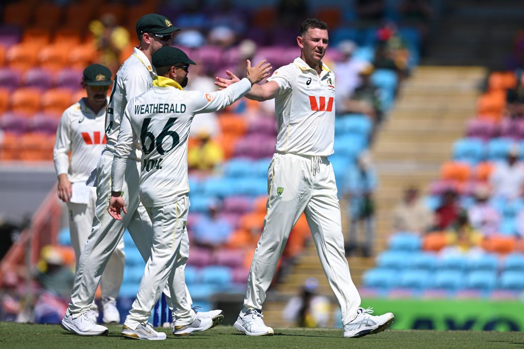Josh Hazlewood of Australia, right, celebrates with teammates after taking the wicket of Mominul Haque of Bangladesh during play on day two of the first cricket test in Darwin, Australia, Friday, Aug. 14, 2026, (James Ross/AAPImage via AP)