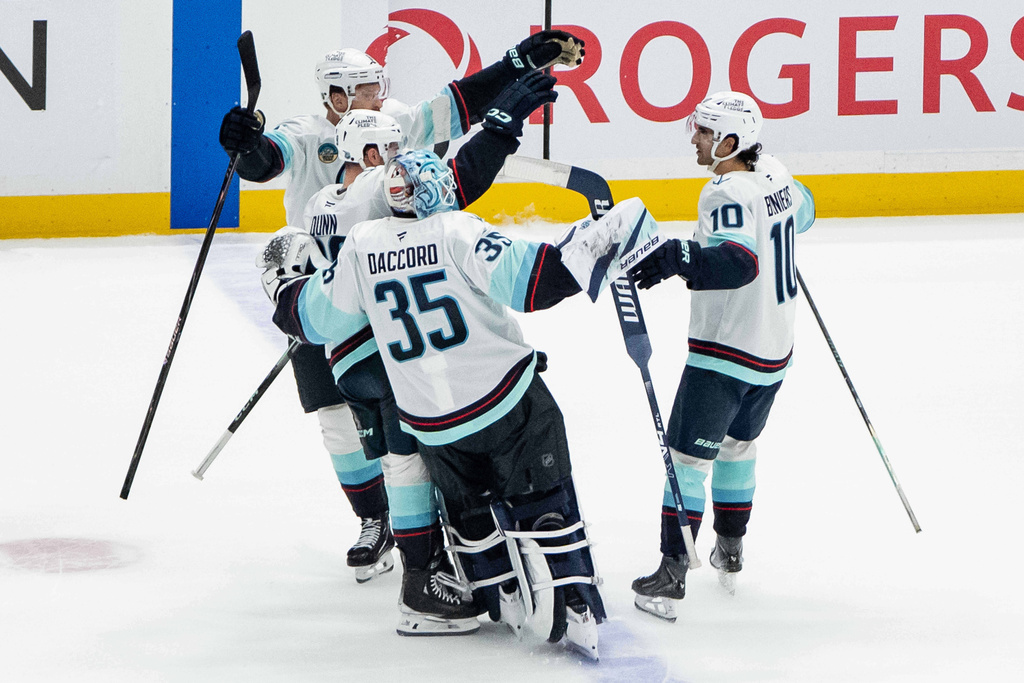Seattle Kraken's Matty Beniers (10) celebrates his winning goal against the Vancouver Canucks with his teammates in shootout NHL hockey action in Vancouver, Friday, Jan. 2, 2026. (Ethan Cairns/The Canadian Press via AP)