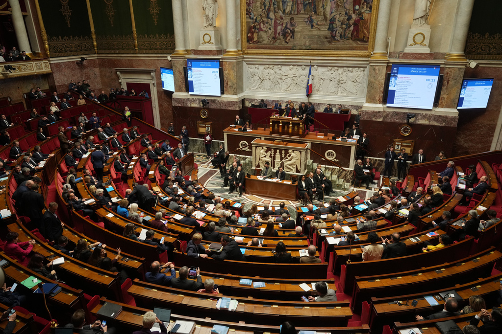 Parliament members sit as France's National Assembly vote on a national health care budget that would suspend Macron's unpopular pension reform raising the retirement age, in Paris, France, Tuesday, Dec. 9, 2025. (AP Photo/Michel Euler)