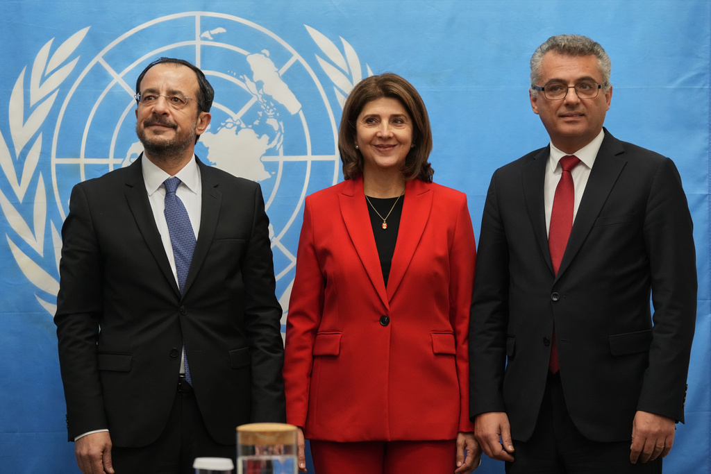Cyprus' President Nikos Christodoulides, left, and the Turkish Cypriot leader Tufan Erhurman, right, meet with the U.N the Personal Envoy of U.N Secretary General Maria Angela Holguin at the U.N compound inside the UN buffer zone in divided capital Nicosia, Cyprus, Thursday, Dec. 11. 2025. (AP Photo/Petros Karadjias, Pool)
