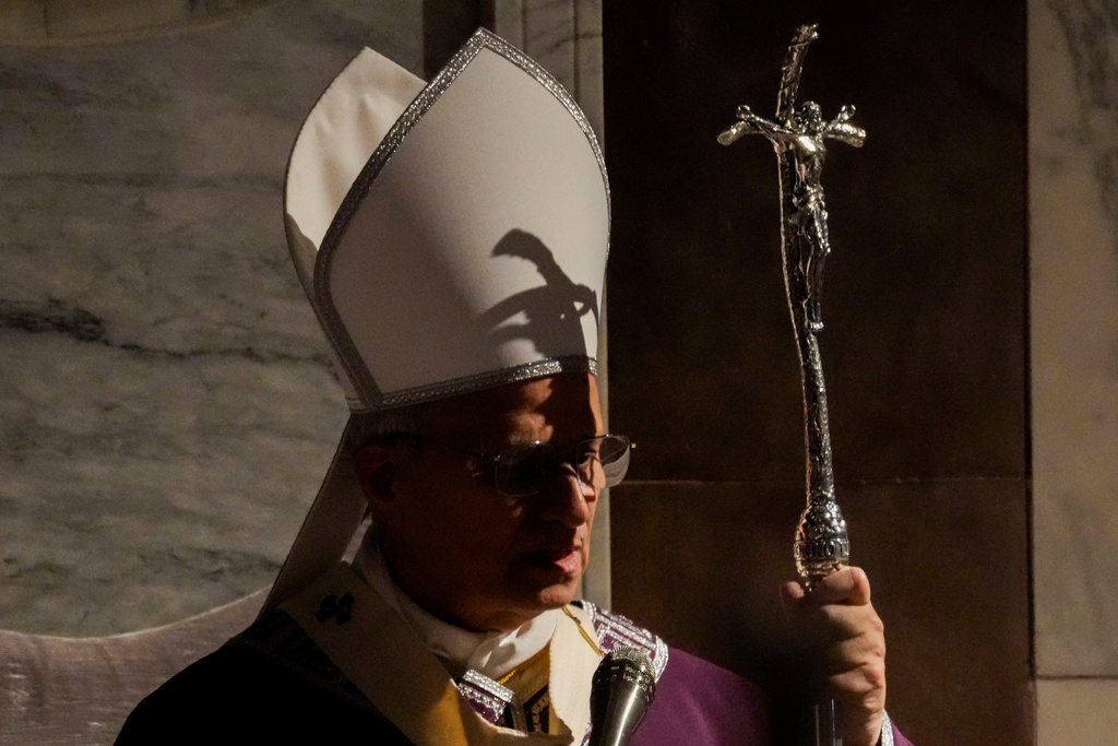 The shadow of the crucifix surmounting his pastoral staff falls across Pope Leo XIV as he presides over Ash Wednesday Mass, marking the start of Catholic Lent, inside the Basilica of Santa Sabina in Rome, Wednesday, Feb. 18, 2026. (AP Photo/Gregorio Borgia)