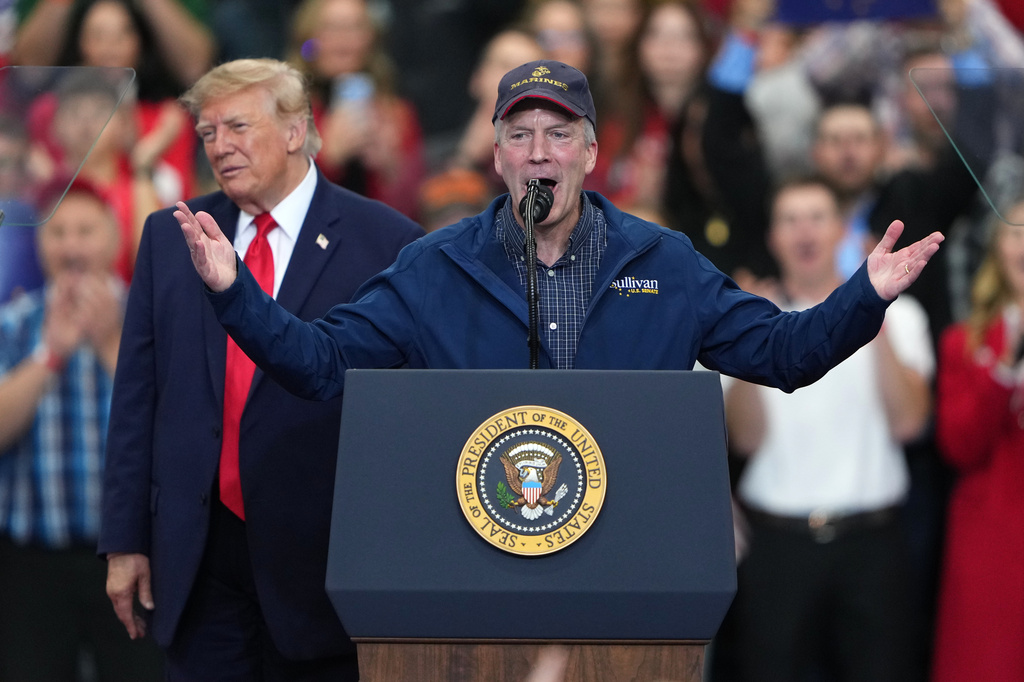 President Donald Trump listens as Sen. Dan Sullivan, R-Alaska, speaks at a campaign rally at the Curtis D. Menard Memorial Sports Center, Tuesday, Oct. 13, 2026, in Wasilla, Alaska. (AP Photo/Lindsey Wasson)