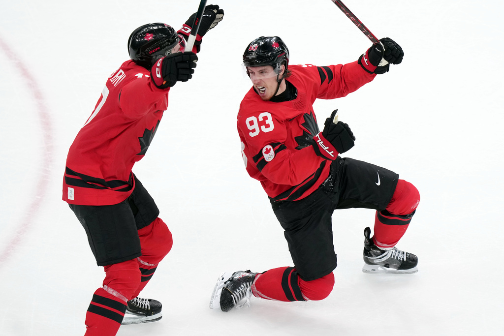 Canada's Mitch Marner (93) and Macklin Celebrini (17) celebrate after Marner scored the winning goal during the overtime period of a men's ice hockey quarterfinal game between Canada and Czechia at the 2026 Winter Olympics, in Milan, Italy, Wednesday, Feb. 18, 2026. (AP Photo/Carolyn Kaster)