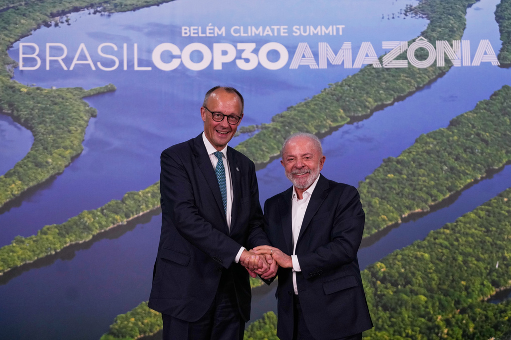 Brazil President Luiz Inacio Lula da Silva, right, and Germany Chancellor Friedrich Merz join hands after meeting during the COP30 U.N. Climate Summit in Belem, Brazil, Friday, Nov. 7, 2025. (AP Photo/Eraldo Peres)