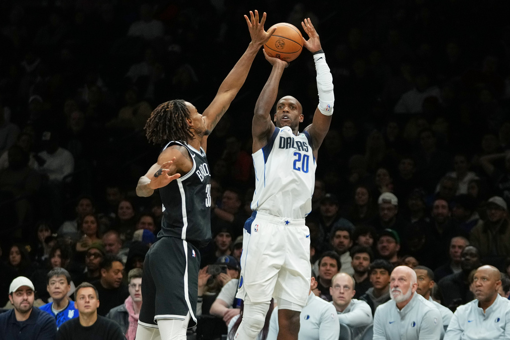 Dallas Mavericks' Khris Middleton (20) shoots over Brooklyn Nets' Nic Claxton (33) during the first half of an NBA basketball game Tuesday, Feb. 24, 2026, in New York. (AP Photo/Frank Franklin II)