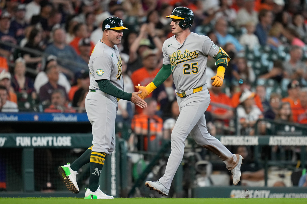 Athletics designated hitter Brent Rooker (25) celebrates after his solo home run against the Houston Astros with third base coach Bobby Crosby during the fifth inning of a baseball game, Sunday, June 7, 2026, in Houston. (AP Photo/Eric Christian Smith)