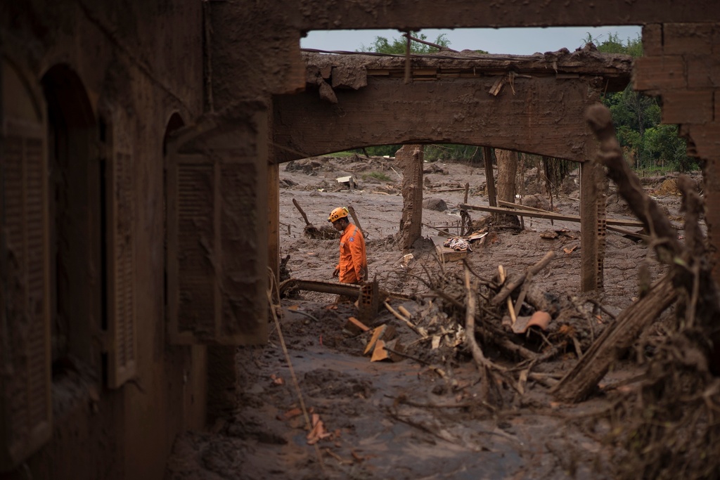 FILE - A rescue worker walks between destroyed houses after a dam burst in the town of Bento Rodrigues, Minas Gerais state, Brazil, Nov. 8, 2015. (AP Photo/Felipe Dana, File)