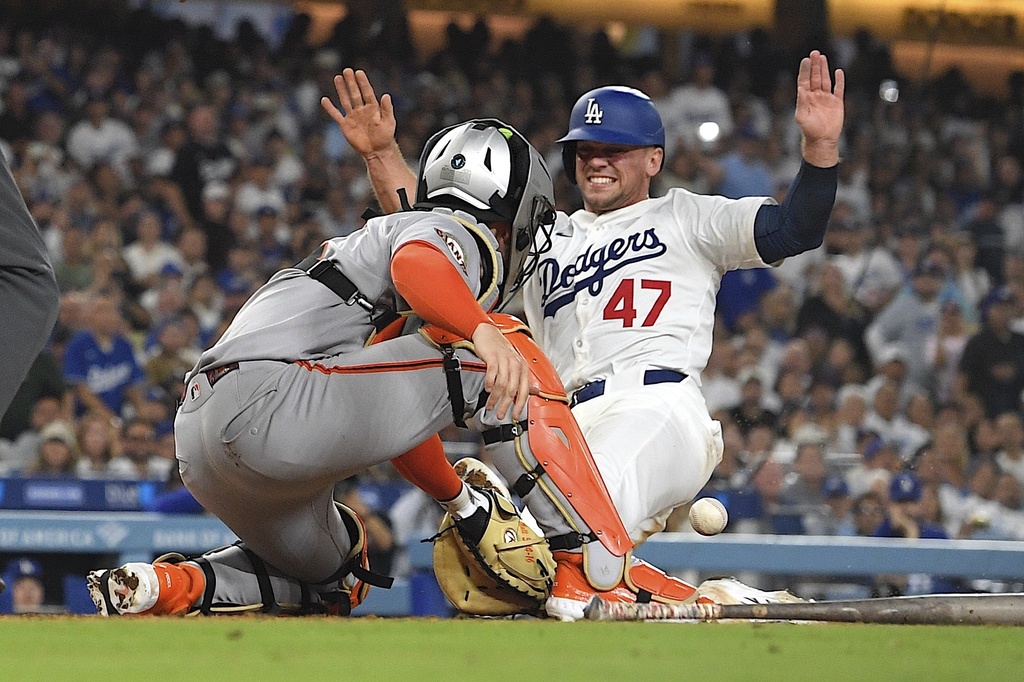 Los Angeles Dodgers' Ben Rortvedt scores on a fielder's choice hit by Mookie Betts as San Francisco Giants catcher Patrick Bailey missed the ball during the sixth inning of a baseball game Thursday, Sept. 18, 2025, in Los Angeles. (AP Photo/Mark J. Terrill)