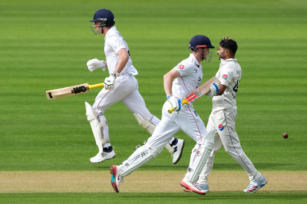 England's Harry Brook, center, and batting partner Dan Lawrence run between the wickets as Pakistan's Khurram Shahzad, right, looks on on day three of the second cricket test match between England and Pakistan in London, Saturday, Aug. 29, 2026. (AP Photo/Dave Shopland)