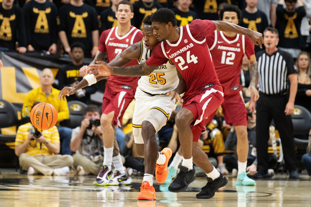 Missouri's Mark Mitchell (25) and Arkansas' Billy Richmond III (24) chase a loose ball during the first half of an NCAA college basketball game, Saturday, March 7, 2026, in Columbia, Mo. (AP Photo/L.G. Patterson)