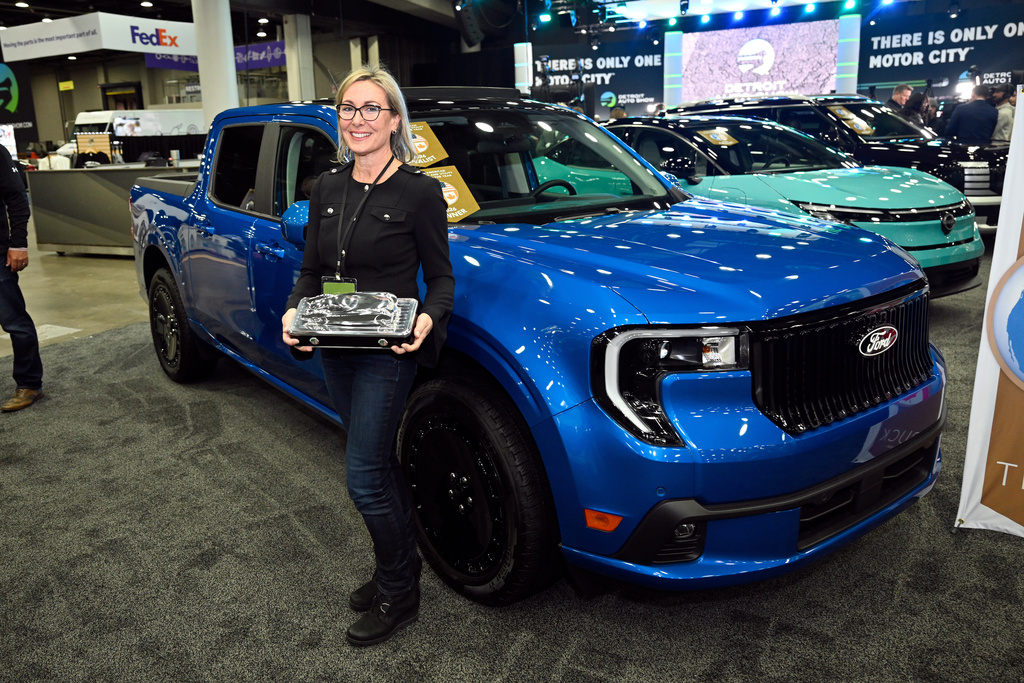 Ford Motor Company Vehicle Programs Director Pamela Wylie holds the North American Truck of the Year award in front of the Ford Maverick Lobo, Wednesday, Jan. 14, 2026, in Detroit. (AP Photo/Jose Juarez)