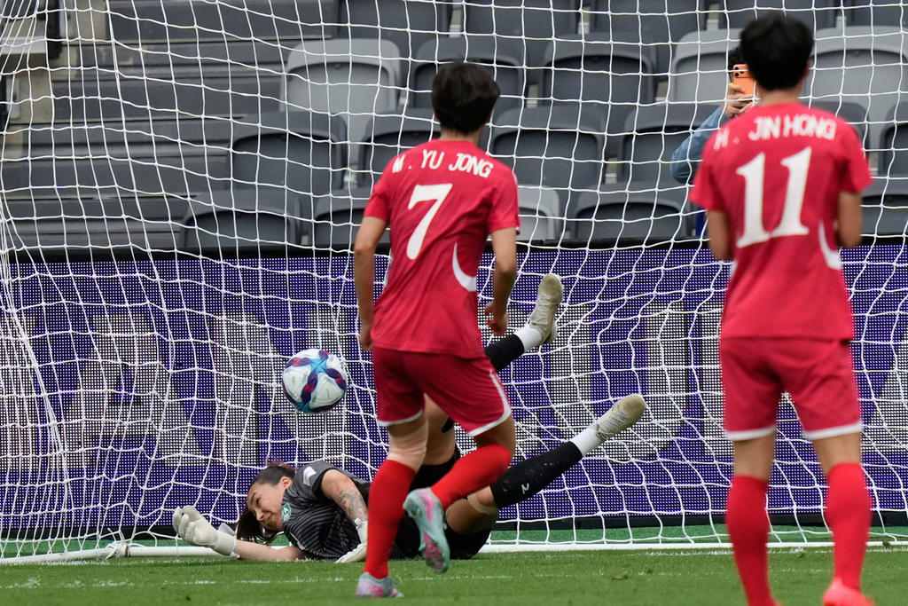 North Korea's Myong Yu Jong, centre, scores from the penalty spot as Uzbekistan's goalkeeper Zarina Saidova dives during the Women's Asia Cup soccer match between North Korea and Uzbekistan in Sydney, Tuesday, March 3, 2026. (AP Photo/Rick Rycroft)