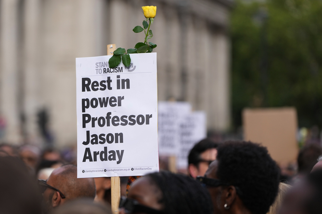 A sign is held during a vigil by Stand Up to Racism in memory of late University of Cambridge professor Jason Arday at Trafalgar Square in London, Monday, Aug. 17, 2026. (AP Photo/Kirsty Wigglesworth)