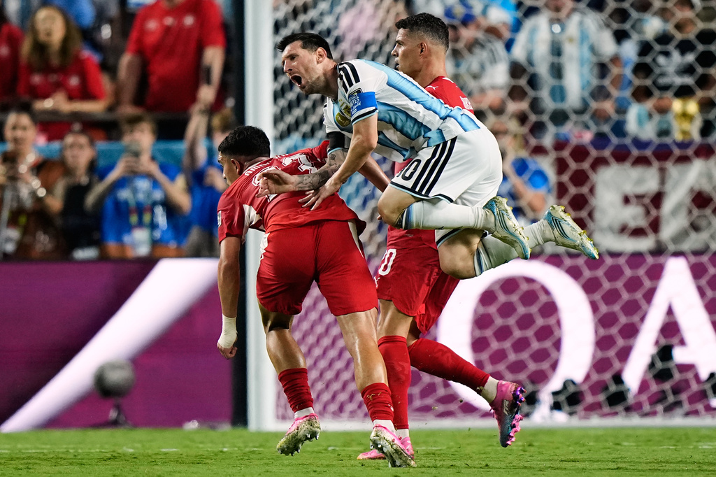 Argentina's Lionel Messi (10) falls while being fouled against by Switzerland's Zeki Amdouni, left, during the World Cup quarterfinal soccer match in Kansas City, Mo., Saturday, July 11, 2026. (AP Photo/Charlie Riedel)