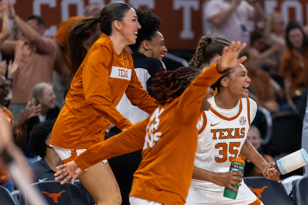 Texas forward Madison Booker (35) celebrates her team scoring against Georgia with guard Sarah Graves, top, during the first half of an NCAA college basketball game Thursday, Feb. 26, 2026, in Austin, Texas. (AP Photo/Stephen Spillman)