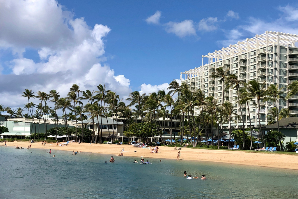 FILE - People are seen on the beach and in the water in front of the Kahala Hotel & Resort in Honolulu, Nov. 15, 2020. (AP Photo/Jennifer Sinco Kelleher, File)