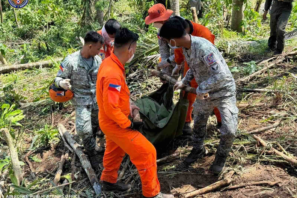 In this photo provided by the Philippine Air Force, Philippine Air Force personnel retrieve the remains of the pilots and crew of the Super Huey helicopter on Wednesday, Nov. 5, 2025, a day after it crashed in Agusan del Sur province, southern Philippines while on a humanitarian and disaster response mission due to Typhoon Kalmaegi. (Philippine Air Force via AP)