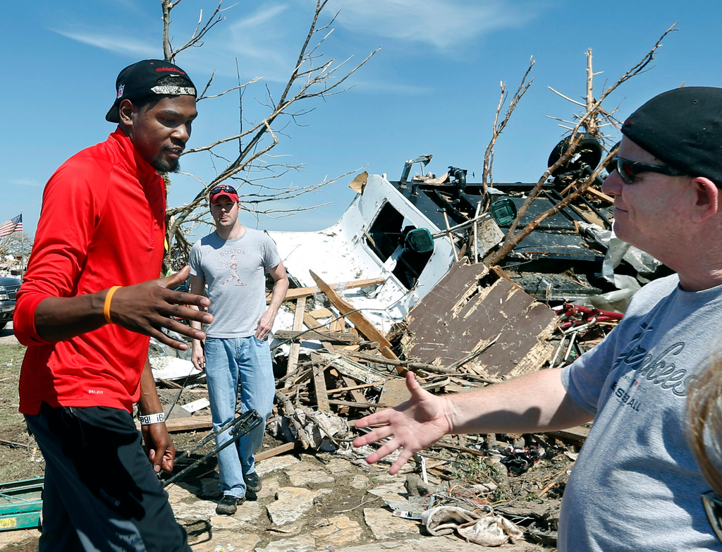 FILE - Oklahoma City Thunder NBA basketball player Kevin Durant greets Tim Kraeger, right, at his tornado-damaged home in Moore, Okla., Wednesday, May 22, 2013. Kraeger is a police officer who Durant knows from his work at the Thunder games. Durant donated $1 million to the American Red Cross for relief efforts. The Thunder matched the $1 million donation. (AP Photo/Sue Ogrocki, File)