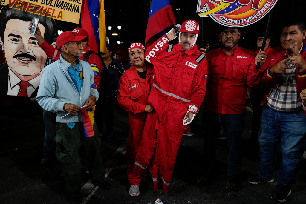 A PDVSA worker of the state-owned oil company carries a cutout of former President Nicolas Maduro dressed as an oil worker during a rally to back an oil reform bill proposed by acting President Delcy Rodriguez to loosen state control and open the industry to private and foreign investment in Caracas, Venezuela, Thursday, Jan. 29, 2026. (AP Photo/Ariana Cubillos)