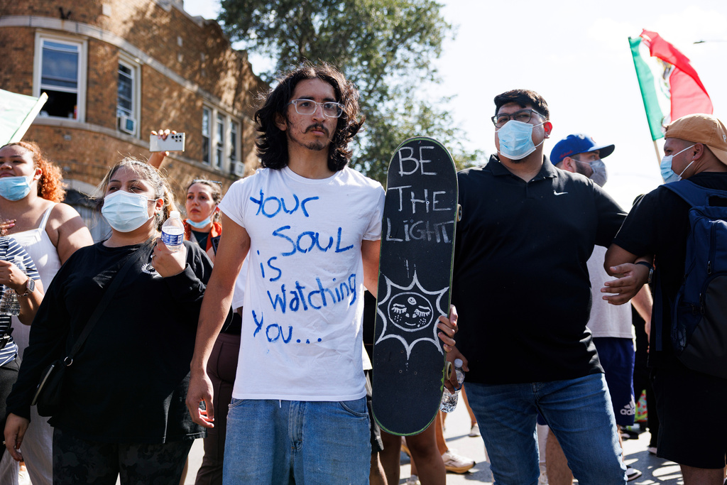 Protesters stand and chant in the Brighton Park neighborhood of Chicago, on Saturday, Oct. 4, 2025, after protesters learned that U.S. Border Patrol shot a woman Saturday morning on Chicago's Southwest Side. (Anthony Vazquez/Chicago Sun-Times via AP)