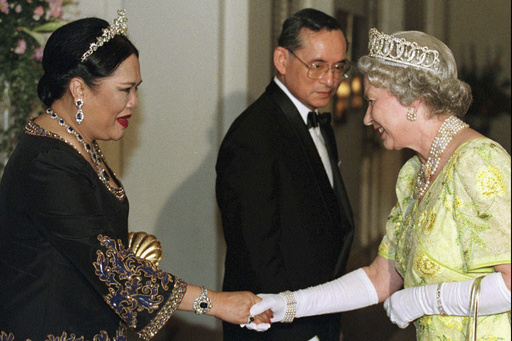 FILE - British Queen Elizabeth II, right, smiles as she greets Thai Queen Sirikit, left, with Thai King Bhumibol Adulyadej looking on at a reception at the British Ambassador's residence in central Bangkok, Oct. 30, 1996. (AP Photo/Pool, File) FILE - British Queen Elizabeth II, right, smiles as she greets Thai Queen Sirikit, left, with Thai King Bhumibol Adulyadej looking on at a reception at the British Ambassador's residence in central Bangkok, Oct. 30, 1996. (AP Photo/Pool, File)