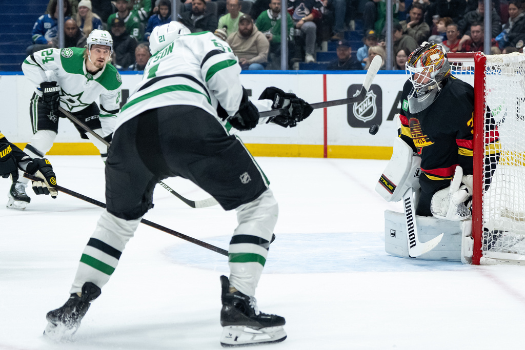 Vancouver Canucks goaltender Kevin Lankinen (32) stops Dallas Stars' Jason Robertson (21) as Roope Hintz (24) watches during the first period of an NHL hockey game in Vancouver, Thursday, Nov. 20, 2025. (Ethan Cairns/The Canadian Press via AP)