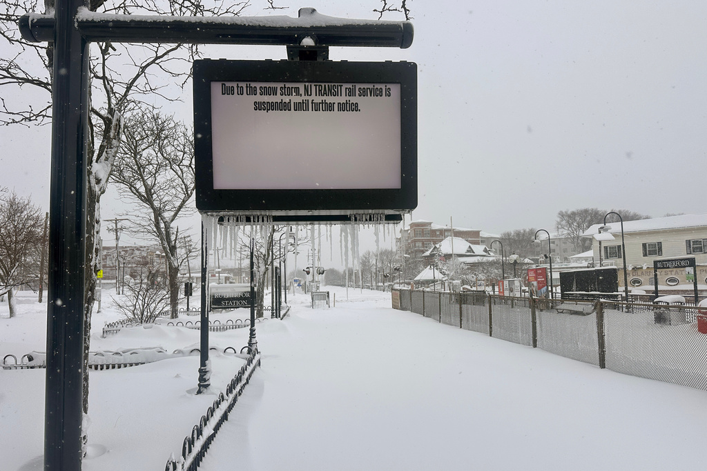 A sign indicates NJ Transit train service suspension due to snow storm conditions in Rutherford, N.J., Monday, Feb. 23, 2026. (AP Photo/Ted Shaffrey)