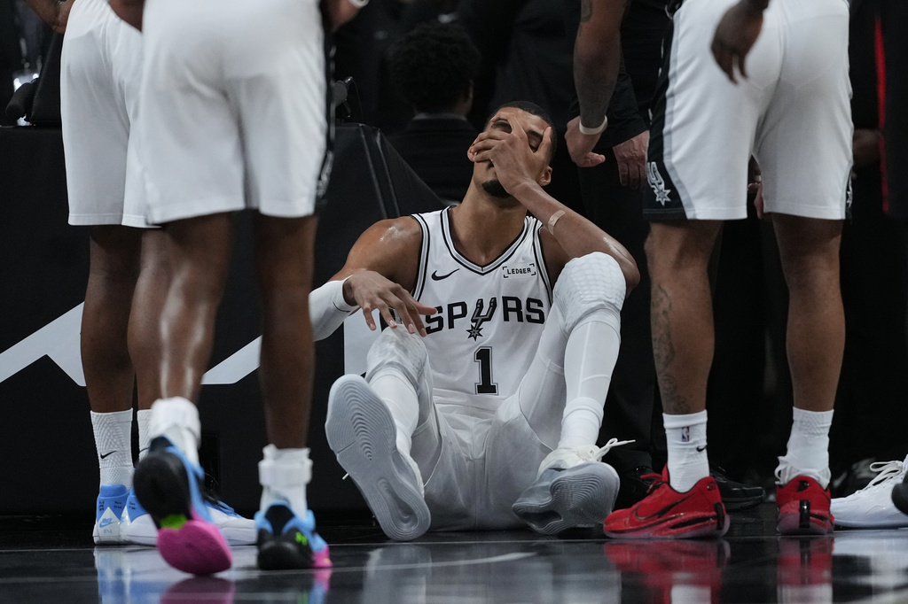 San Antonio Spurs forward Victor Wembanyama (1) sits on the court after a hard fall during the first half in Game 2 of a first-round NBA playoffs basketball series against the Portland Trail Blazers in San Antonio, Tuesday, April 21, 2026. (AP Photo/Eric Gay)