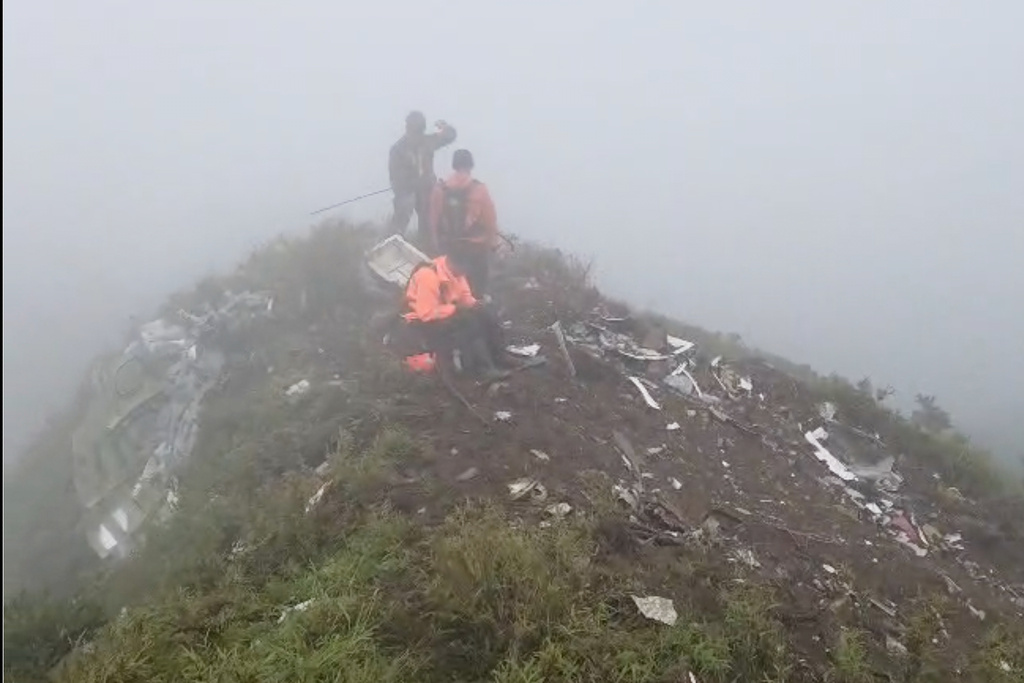 In this photo provided by the Indonesian National Search and Rescue Agency (BASARNAS), members of its rescue team conduct a searching operation amid debris of an airplane around Mount Bulusaraung, South Sulawesi province, Indonesia, Sunday, Jan. 18, 2026, after the turboprop ATR 42-500 lost contact Saturday. (BASARNAS via AP)