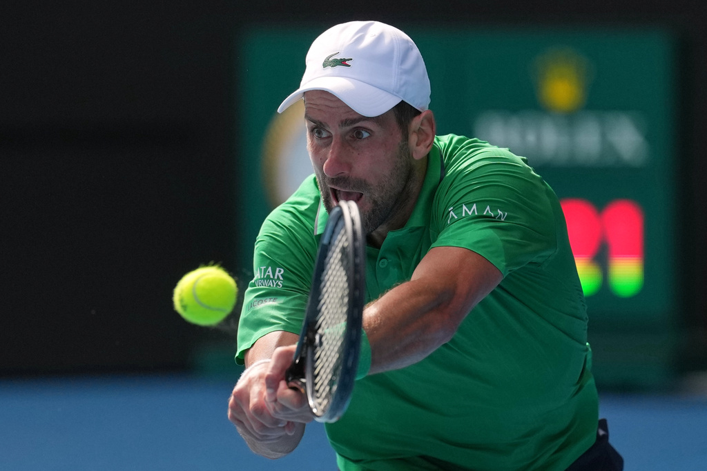 Novak Djokovic of Serbia plays a backhand return to Lorenzo Musetti of Italy during their quarterfinal match at the Australian Open tennis championship in Melbourne, Australia, Wednesday, Jan. 28, 2026. (AP Photo/Dita Alangkara)