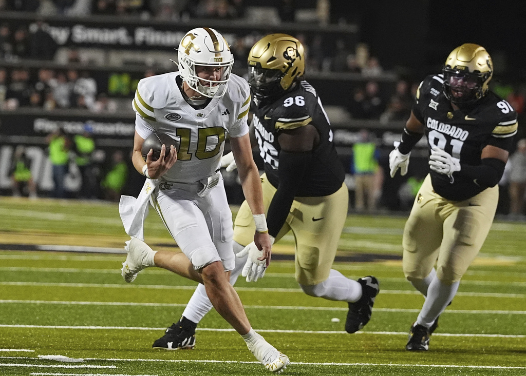 Georgia Tech quarterback Haynes King, left, runs for a touchdown past Colorado defensive tackle Jehiem Oatis, center, and defensive end Brandon Davis-Swain in the second half of an NCAA college football game Friday, Aug. 29, 2025, in Boulder, Colo. (AP Photo/David Zalubowski)