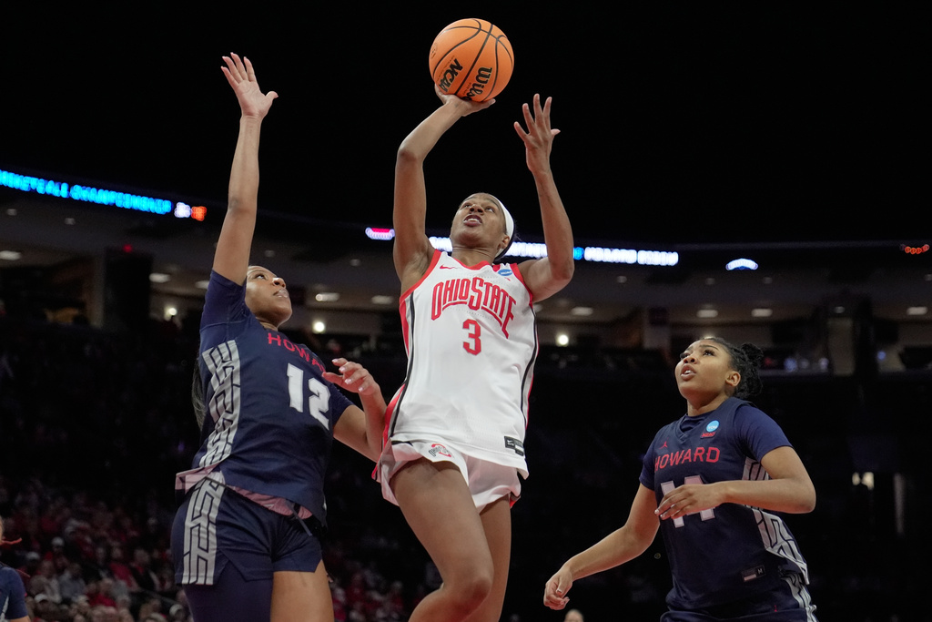 Ohio State guard Kennedy Cambridge (3) shoots between Howard forward Dally Moreno (12) and forward Jada Kendrick, right, in the first half in the first round of the NCAA college basketball tournament, Saturday March 21, 2026, in Columbus, Ohio. (AP Photo/Sue Ogrocki)