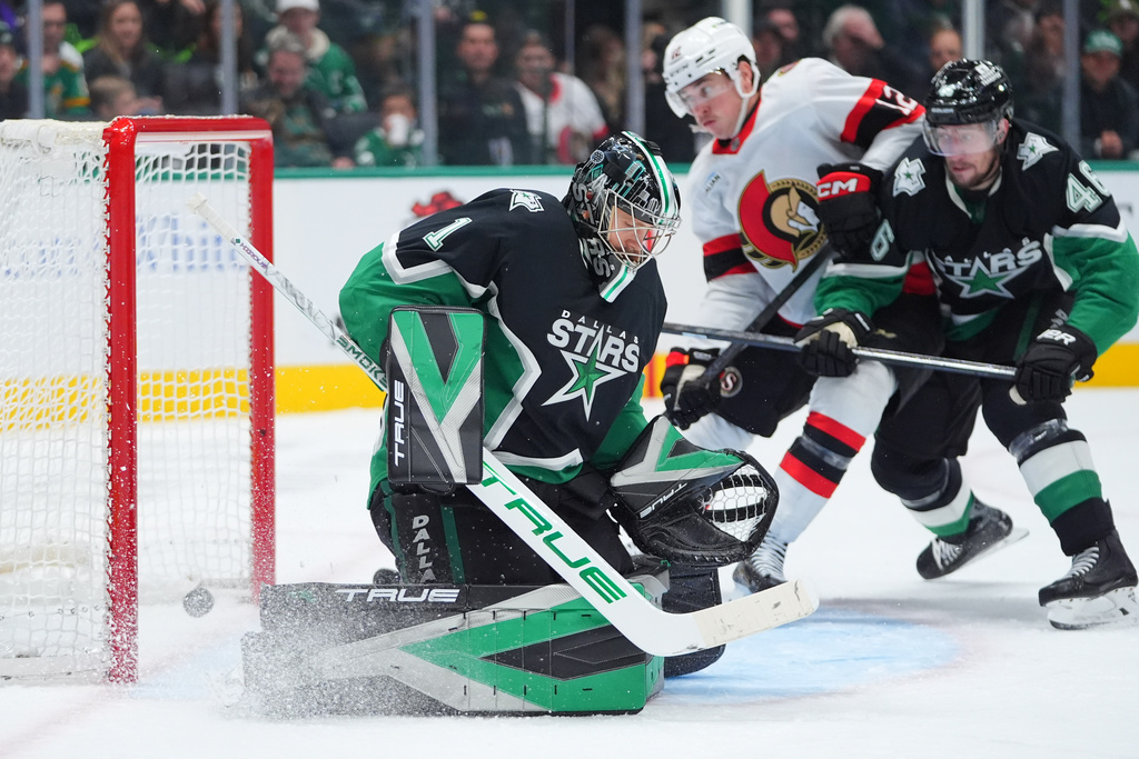 Dallas Stars goaltender Casey Desmith (1) allows a goal by Ottawa Senators defenseman Jake Sanderson as Senators center Shane Pinto (12) and Stars defenseman Ilya Lyubushkin (46) skate in during the second period of an NHL hockey game, Sunday, Nov. 30, 2025, in Dallas. (AP Photo/LM Otero)