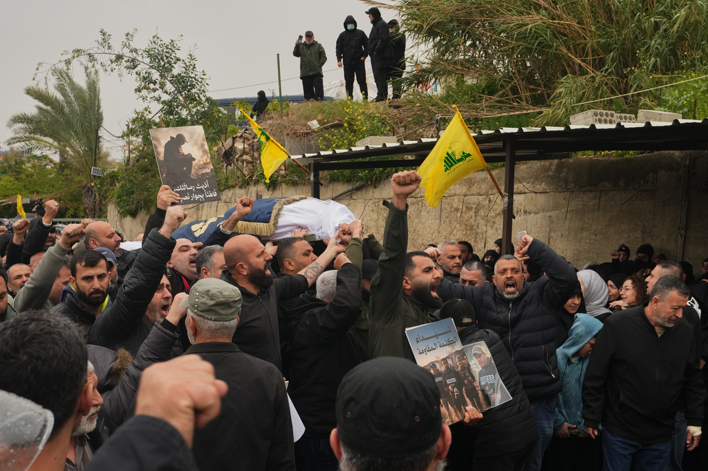 Mourners chant slogans as they carry the coffins of Hezbollah's Al-Manar TV correspondent Ali Shoeib, Al-Mayadeen TV reporter Fatima Ftouni and cameraman Ali Ftouni, who were killed Saturday in an Israeli airstrike in southern Lebanon, during their funeral procession at a temporary cemetery in Dahiyeh, Beirut's southern suburbs, Lebanon, Sunday, March 29, 2026. (AP Photo/Hassan Ammar)