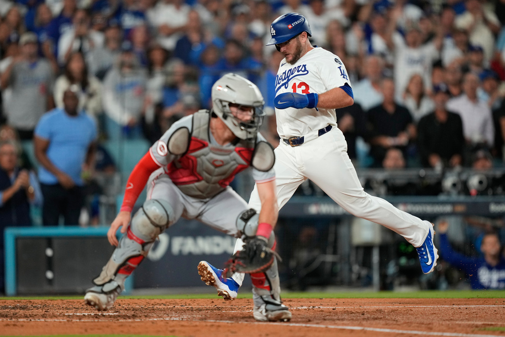 Los Angeles Dodgers' Max Muncy scores past Cincinnati Reds catcher Tyler Stephenson on a double by Kiké Hernández during the fourth inning in Game 2 of the National League Wild Card baseball playoff series Wednesday, Oct. 1, 2025, in Los Angeles. (AP Photo/Mark J. Terrill)