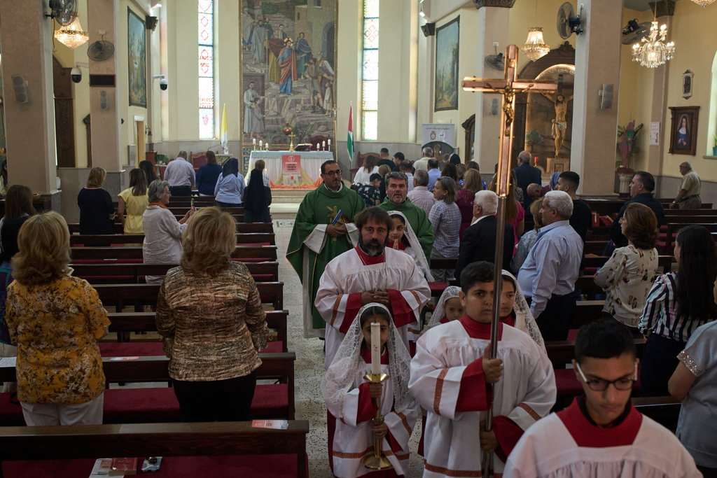 Catholic parish priest Bashar Fawadleh, center left, walks in procession during morning Mass at the Christ the Redeemer Church in the West Bank village of Taybeh, Sept. 28, 2025. (AP Photo/Leo Correa)