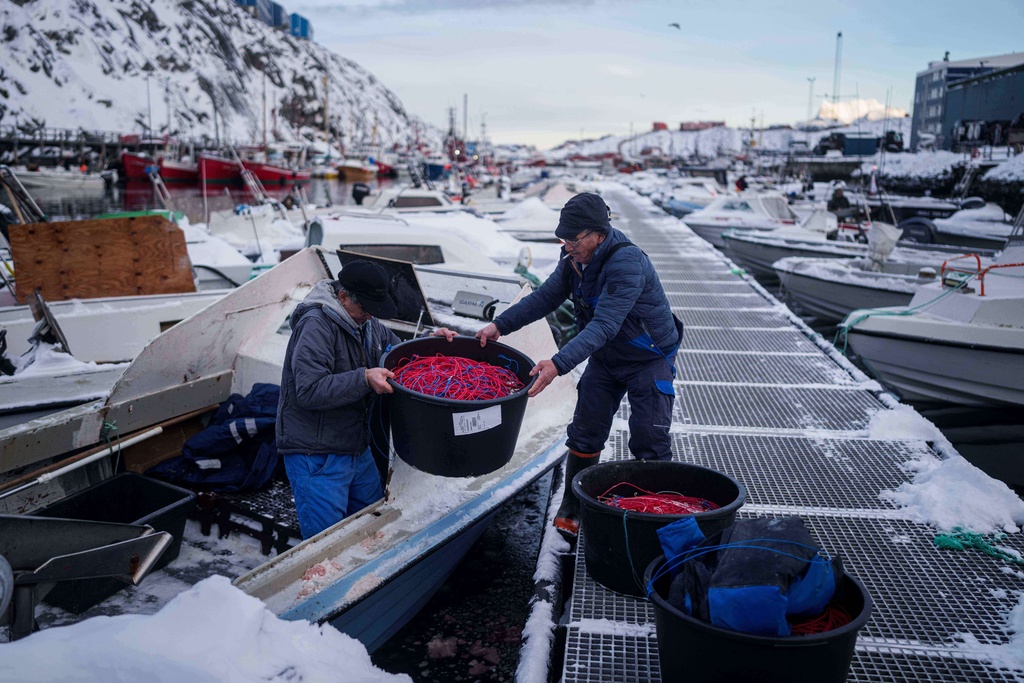 Fishermen load fishing lines into a boat in the harbor of Nuuk, Greenland, Wednesday, Jan. 14, 2026. (AP Photo/Evgeniy Maloletka)
