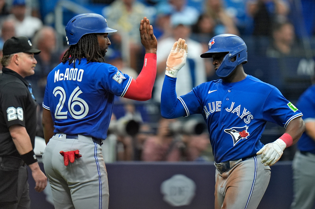 Toronto Blue Jays' Daz Cameron and Charles McAdoo (26) celebrate after scoring on a two-run single by George Springer off Tampa Bay Rays pitcher Casey Legumina during the seventh inning of a baseball game Thursday, Aug. 20, 2026, in St. Petersburg, Fla. (AP Photo/Chris O'Meara)