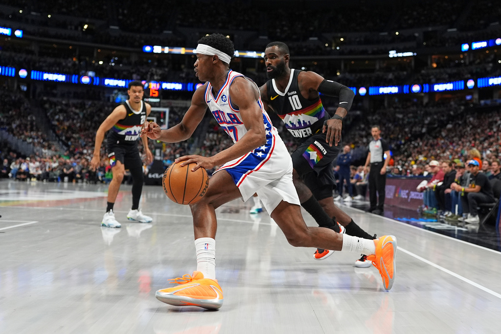 Philadelphia 76ers guard Vj Edgecombe, front, drives past Denver Nuggets guard Tim Hardaway Jr. in the first half of an NBA basketball game Tuesday, March 17, 2026, in Denver. (AP Photo/David Zalubowski)