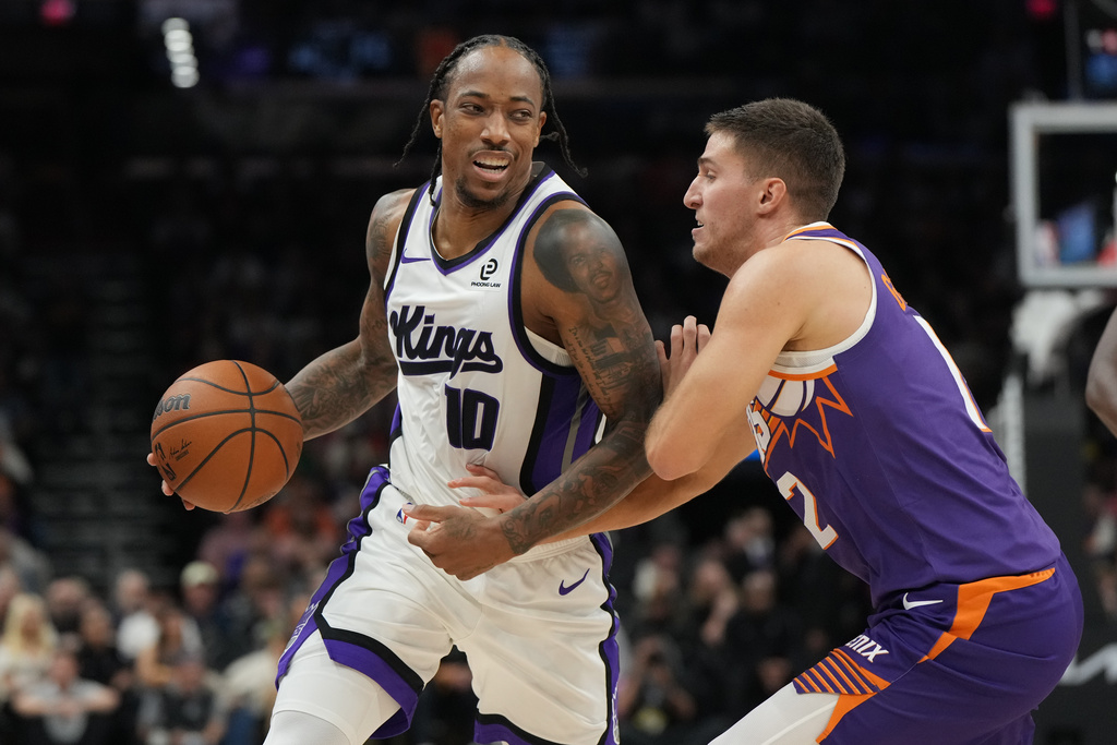 Sacramento Kings guard DeMar DeRozan (10) shields the ball from Phoenix Suns guard Collin Gillespie during the first half of an NBA basketball game, Wednesday, Oct. 22, 2025, in Phoenix. (AP Photo/Rick Scuteri)