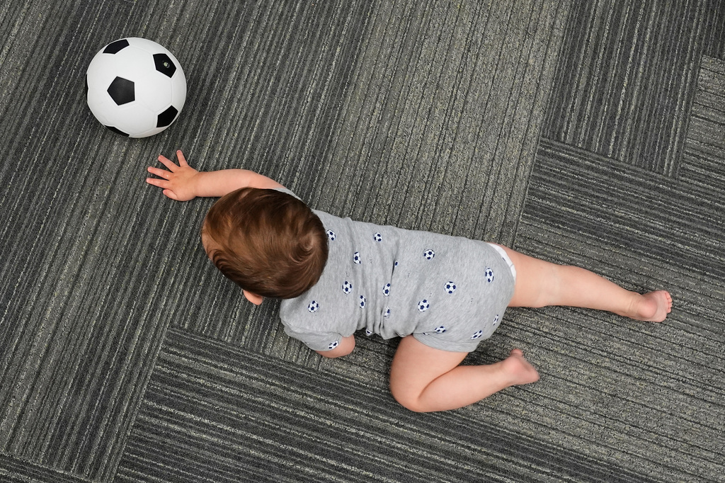 Ten-month-old Beck Ehinger plays with a soccer ball at a program introducing toddlers to the sport ahead of the World Cup soccer tournament Thursday, June 4, 2026, in Lenexa, Kan. (AP Photo/Charlie Riedel)