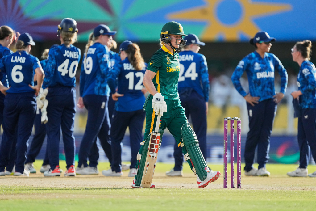 South Africa's Anneke Bosch walks off the field after losing his wicket as England's players celebrate during the ICC Women's Cricket World Cup match between England and South Africa at Barsapara Cricket Stadium in Guwahati, India, Friday, Oct. 3, 2025. (AP Photo/Anupam Nath)