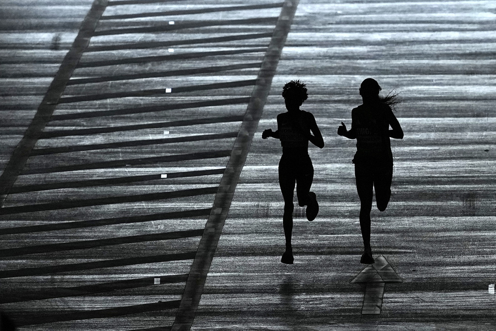 Gold medalist Kenya's Peres Jepchirchir, left, and silver medalist Ethiopia's Tigst Assefa enter the stadium to finish the women's marathon at the World Athletics Championships in Tokyo, Sunday, Sept. 14, 2025. (AP Photo/Matthias Schrader)