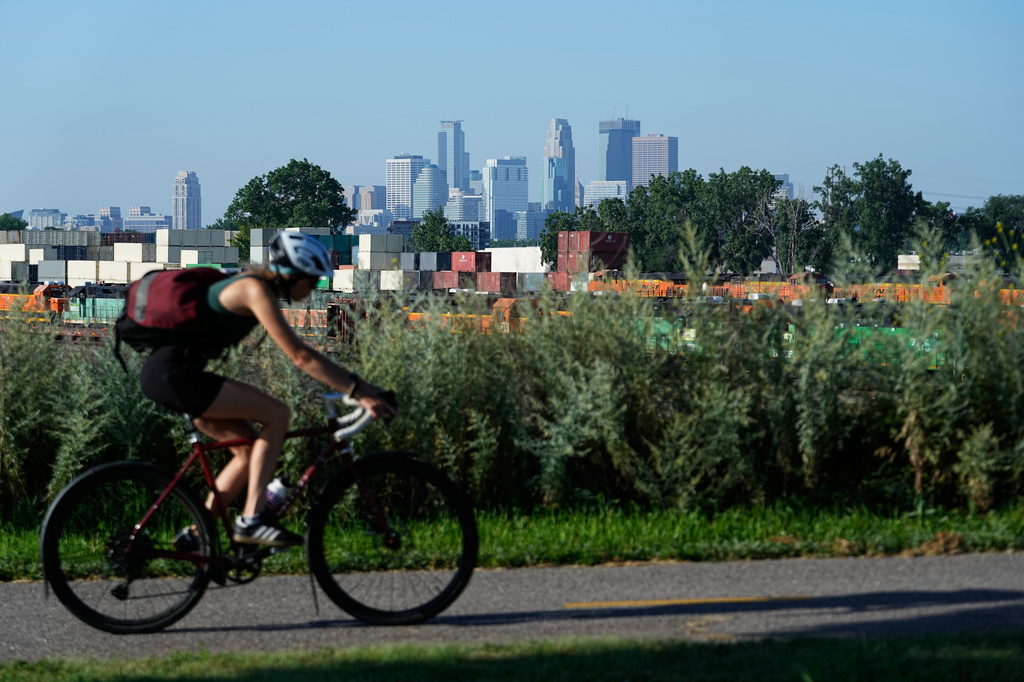 A cyclist passes the Minneapolis skyline along St. Anthony Parkway as smoke from wildfires in Canada and Northern Minnesota sets in, Wednesday, July 15, 2026. (AP Photo/Ellen Schmidt)