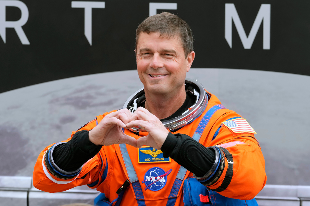 Mission Commander Reid Wiseman makes a heart with his hands as he leaves the Operations and Checkout Building for a trip to Launch Pad 39-B and a planned liftoff on NASA's Artemis II moon rocket at the Kennedy Space Center Wednesday, April 1, 2026, in Cape Canaveral, Fla. (AP Photo/Chris O'Meara)